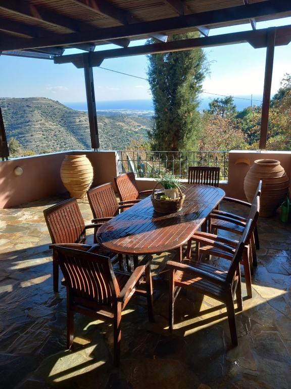 a wooden table and chairs on a patio at Elis superb house in Psathíon