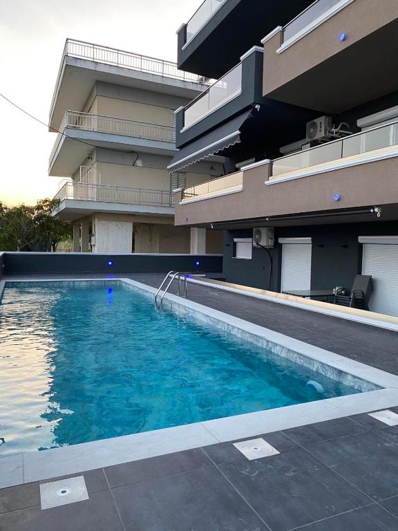a large swimming pool in front of a building at Apartman Velickovic in Paralia Katerinis