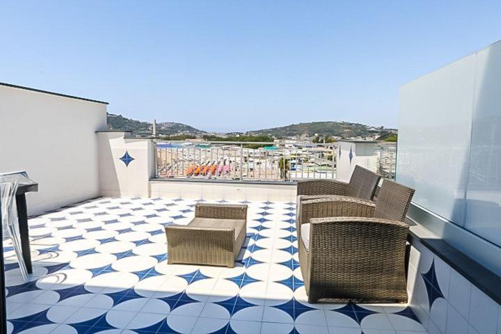 a balcony with chairs and a tiled floor at Agri resort La Dragonara in Bacoli