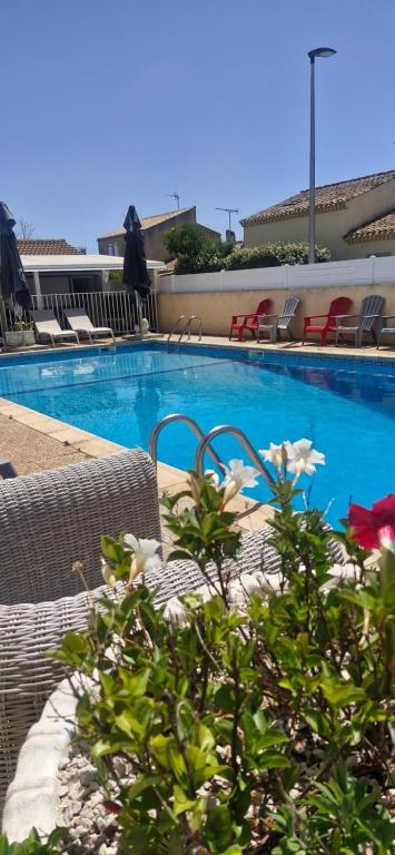 a swimming pool with chairs and a table with a plant at rev'hotel in Vias
