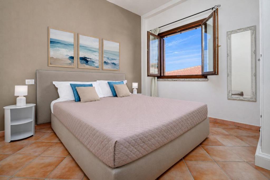 a bedroom with a large bed and a window at Agio Porto Cervo in Liscia di Vacca