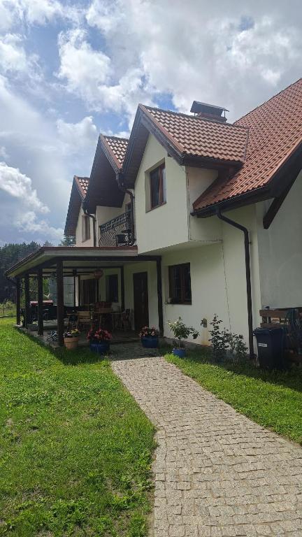 a large white house with a walkway in front of it at Agroturystyka Giławy in Giławy