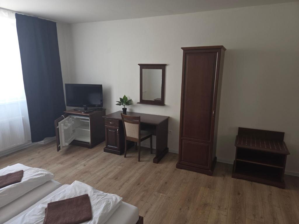 a bedroom with a bed and a desk and a mirror at Laguna ubytovanie 2 A in Trenčín