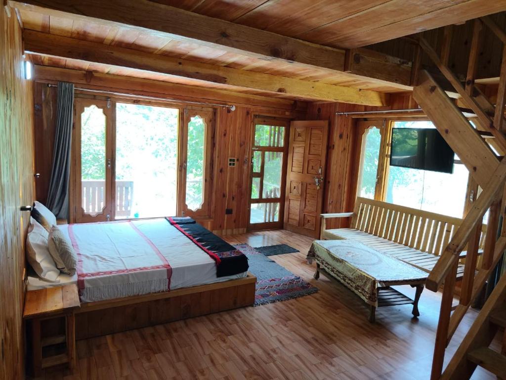 Ein Schlafzimmer in einer Blockhütte mit einem Bett und einer Bank in der Unterkunft Him cottage in Gushaini