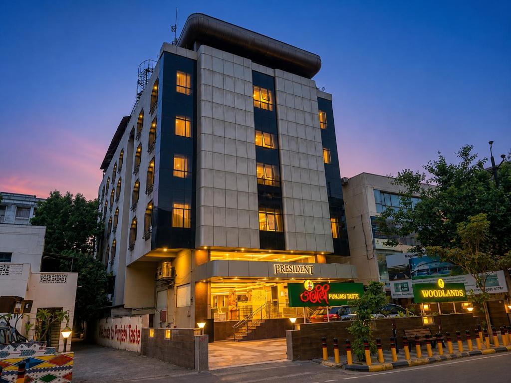 a tall building with lights in front of it at Hotel President, Pure Veg in Indore