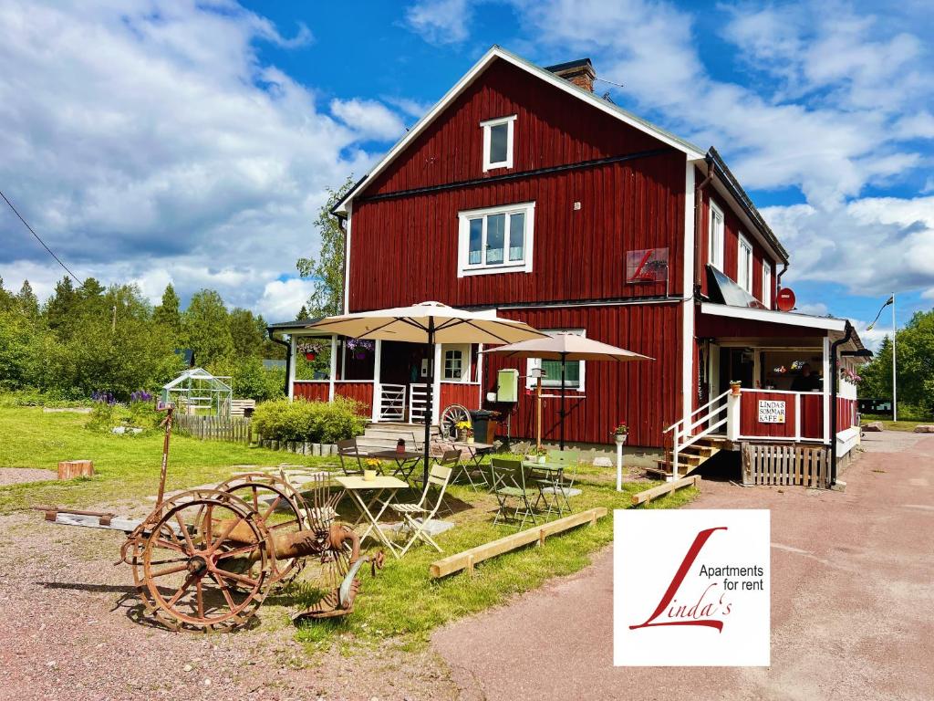 a red barn with an umbrella and a wheel at Linda's Apartment in Sörsjön