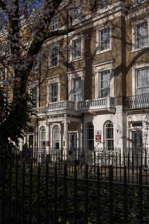 an old house with a fence in front of it at Best Western Plus Delmere Hotel in London