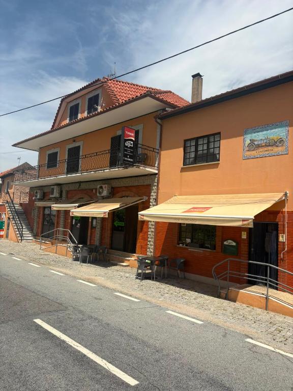 ein Gebäude mit Regenschirmen am Straßenrand in der Unterkunft House Calhambeque in Meimoa
