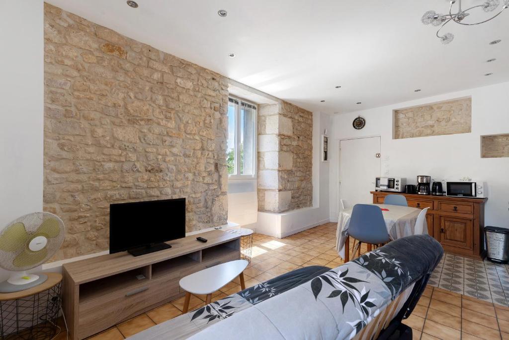 a living room with a couch and a tv at Studio 5 - 3 min du Futuroscope in Chasseneuil-du-Poitou