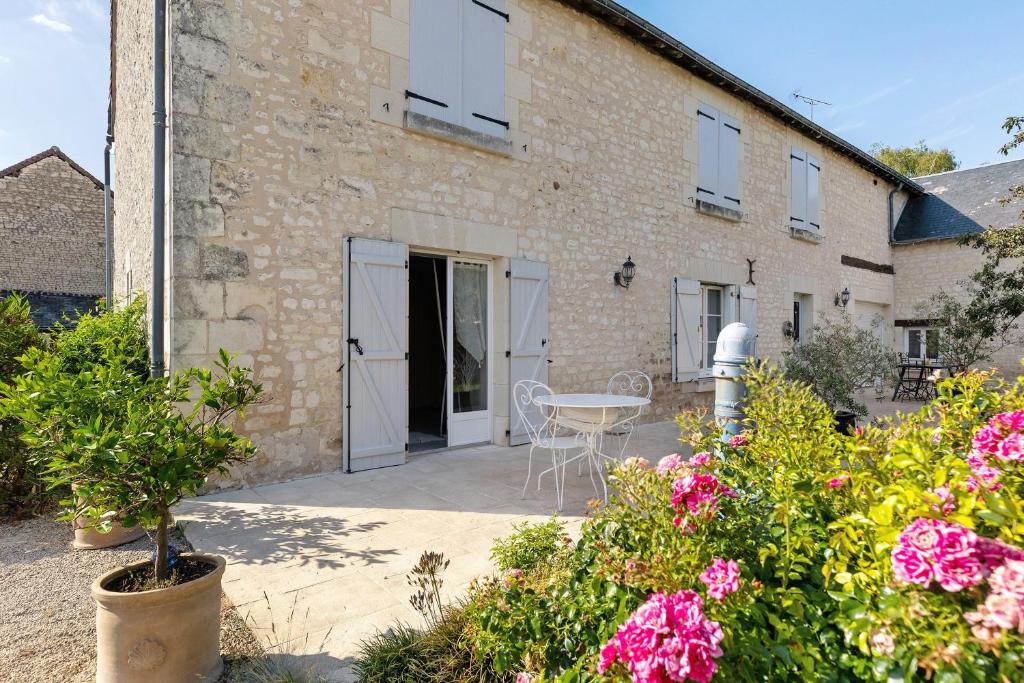 a patio with a table and flowers in front of a building at Lacelledort in La Celle-Saint-Avant