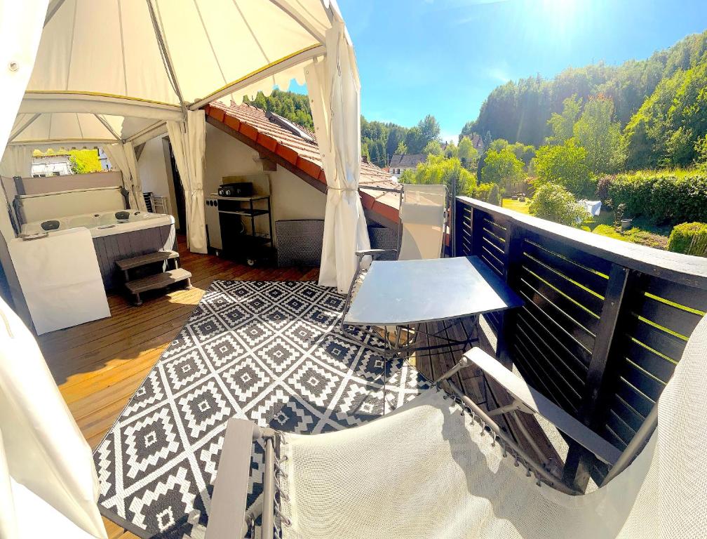 a balcony with a tent with a tub and a table at Suite Verte Vallée Meisenthal spa privatif in Meisenthal