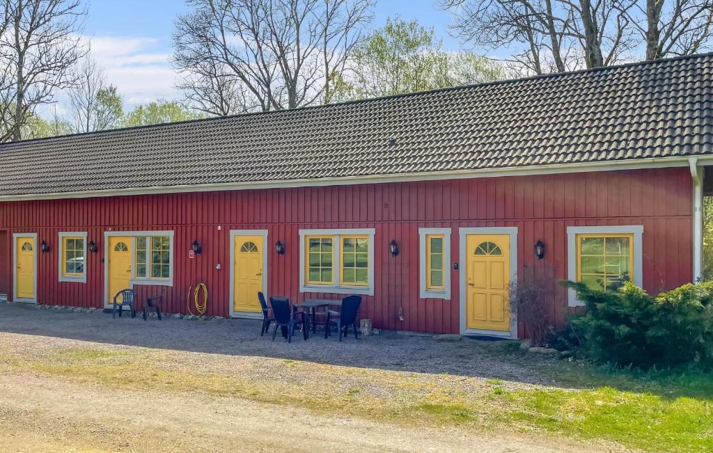 a red building with yellow doors and tables and chairs at 1 Bedroom Lovely Apartment In Värnamo in Värnamo