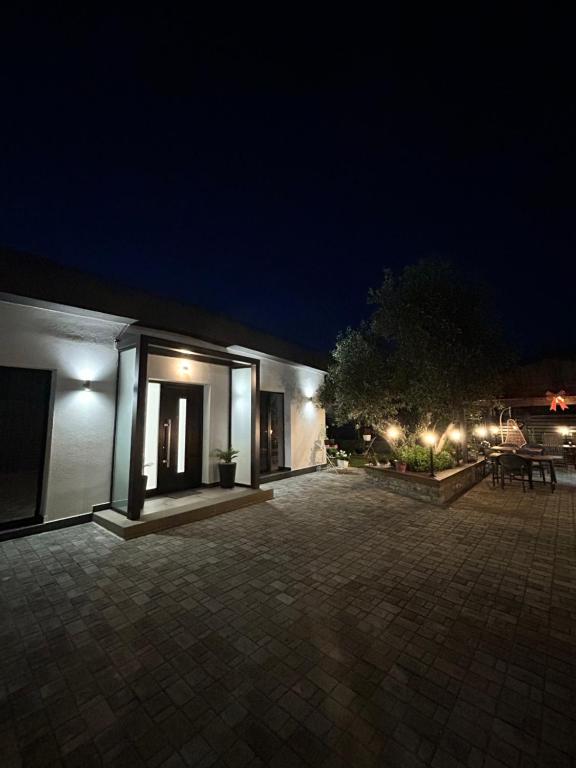 a building with a patio at night with lights at Villa Mucenji in Përmet