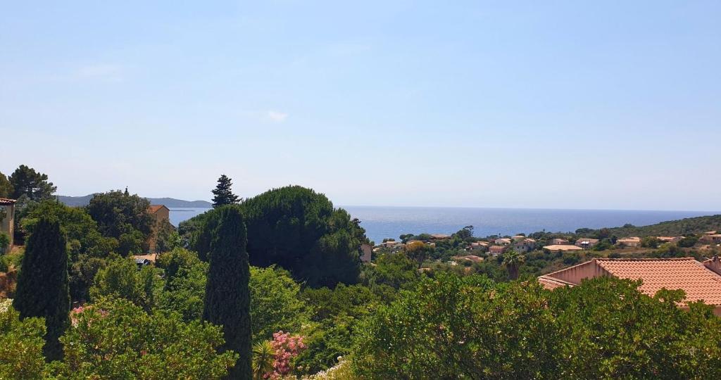 a view of a town with trees and the ocean at Minavita - Vue mer, Plage à pied, Ruppione, Corse in Pietrosella