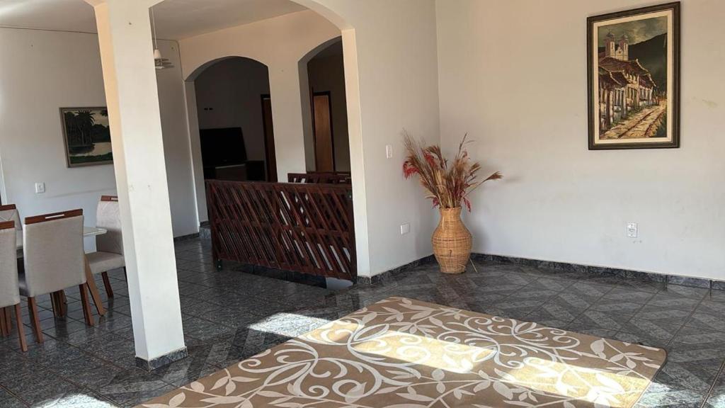 a living room with a vase sitting on the floor at Casa confort - Vicente pires in Brasília
