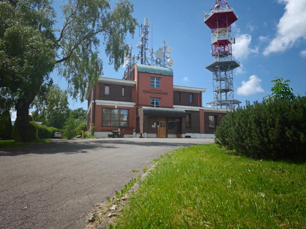 a building with a tower next to a street at Riegrova Chata Kozákov in Semily