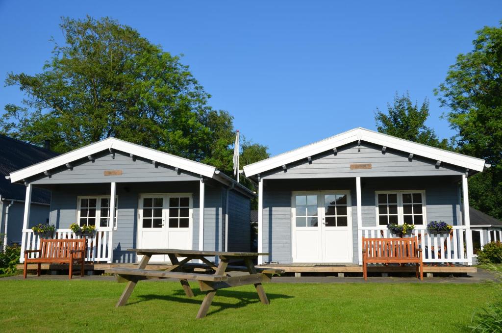 two blue buildings with a picnic table in front of them at Brakkerhus in Egtved