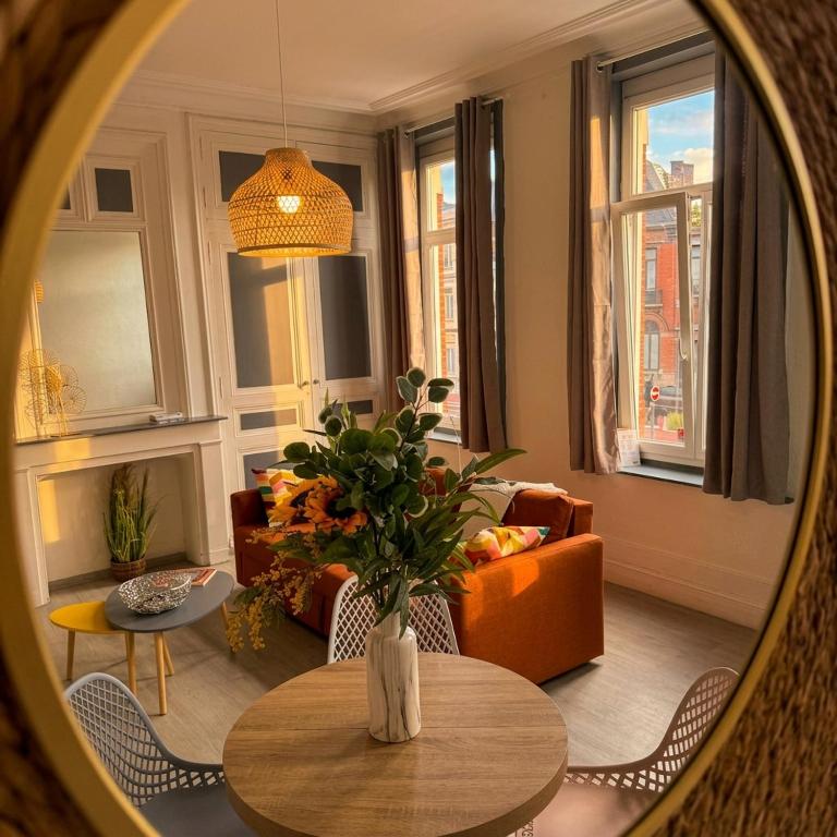 a living room with a table and a couch at Beau 2 pièces climatisé, beaux volumes et lumineux - toutes commodités - Lille Gares direct en 30 minutes in Tourcoing