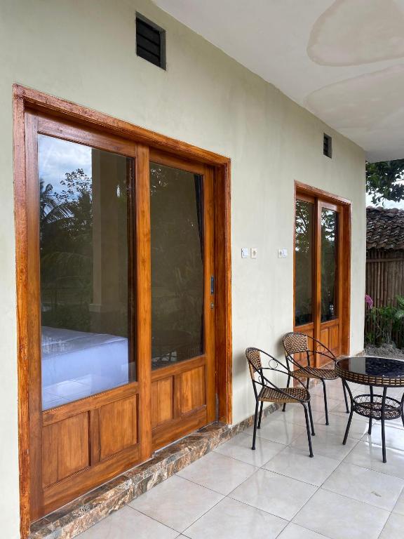 a patio with a glass door and a table and chairs at Sabin view homestay in Banyuwangi