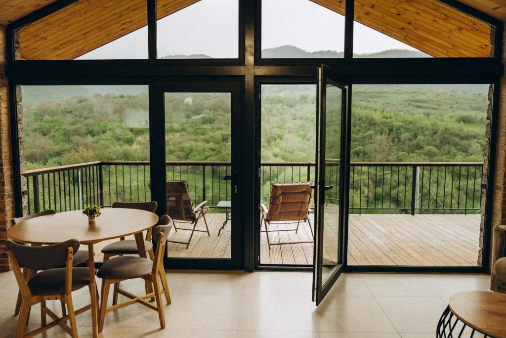 a room with a table and chairs on a deck at Casa Monti in Ijevan