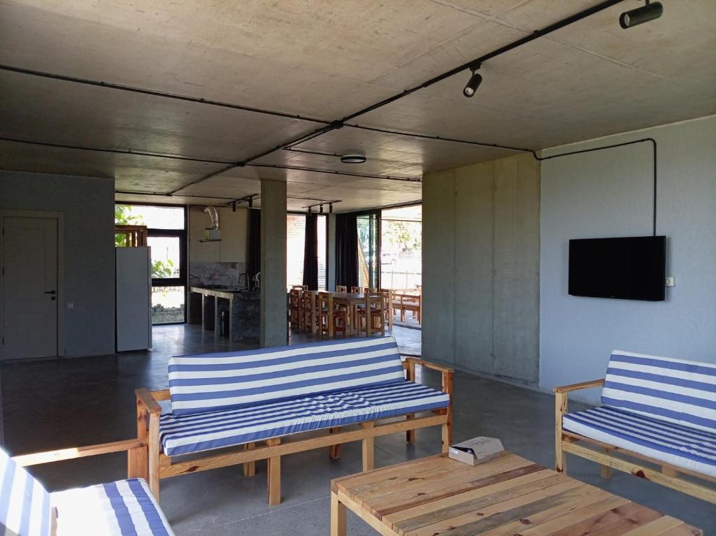 two blue benches in a room with a tv at IO House in Urekis Sadguri