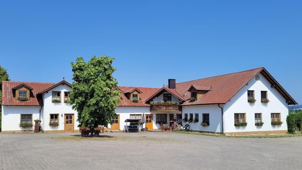 a large white building with a tree in front of it at Bauernhof Nißl in Neunburg vorm Wald