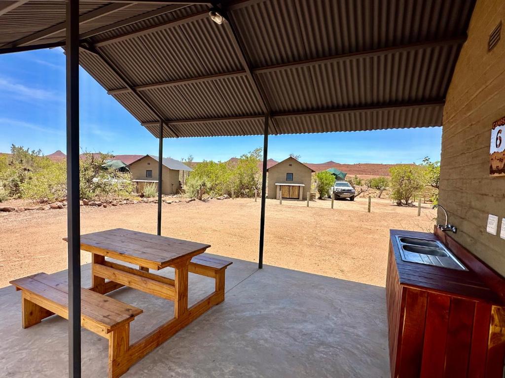 a picnic table and a bench on a patio at Palmwag Campsite in Palm