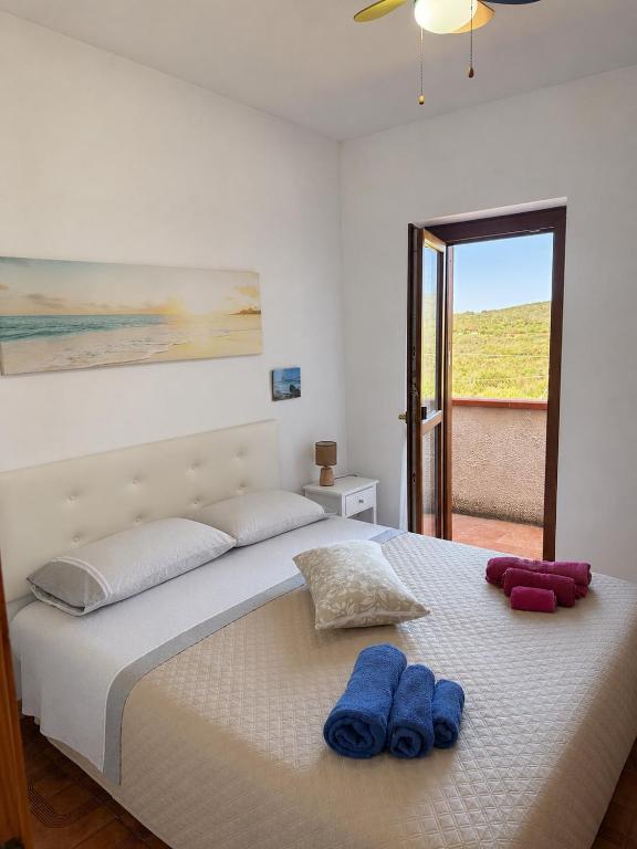 a bedroom with a bed with two blue towels on it at La Vela Apartment in Stintino