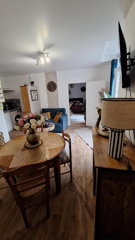 a living room with a table and a couch at Libre comme l'air - Appartement - Terrasse - 1 Chambre in Ruffec