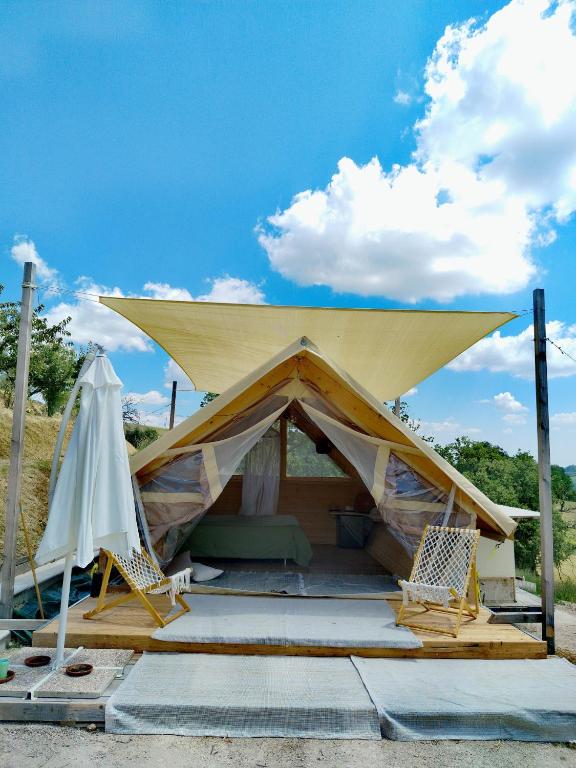 a tent with two chairs and a umbrella at Glamping Casacocco' in San Ginesio