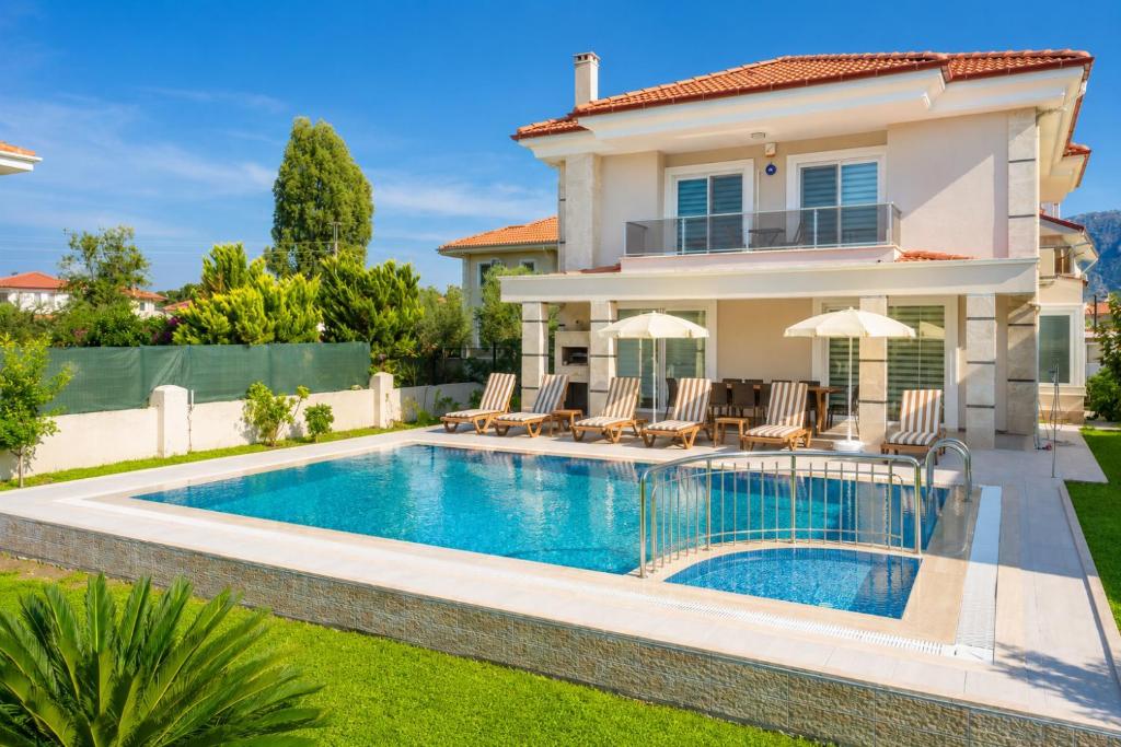 a villa with a swimming pool in front of a house at Villa Ozcelik in Dalyan
