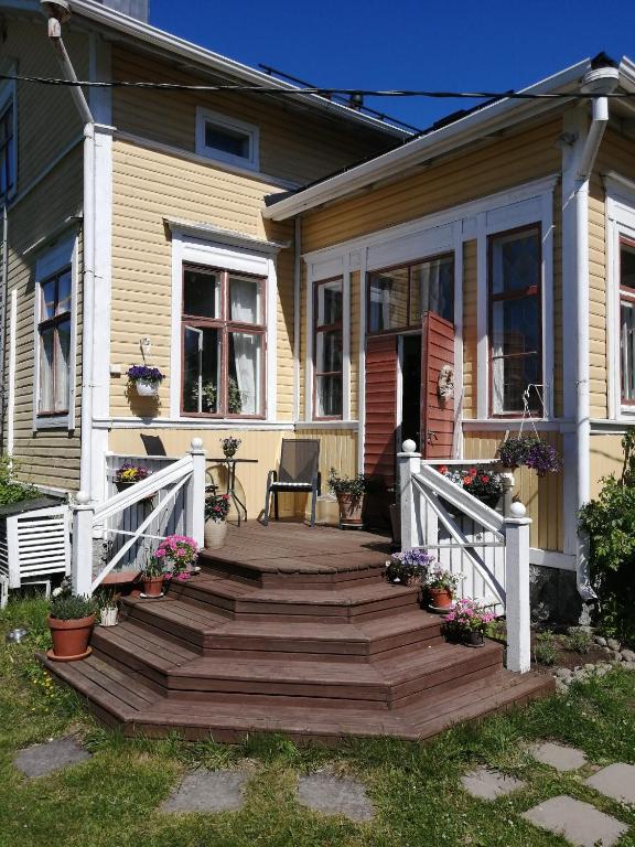 a house with a wooden staircase leading to a porch at Foggy Island B&B in Kaskö