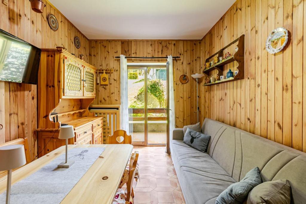 a living room with a couch and a table at Eldann Apartment - Tradizione e Relax a Sappada in Sappada