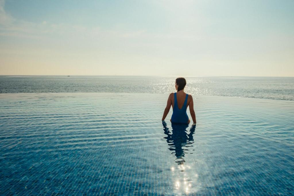 a person standing in the water in the ocean at 1926 Les Bains Private Spa Suites in Sliema