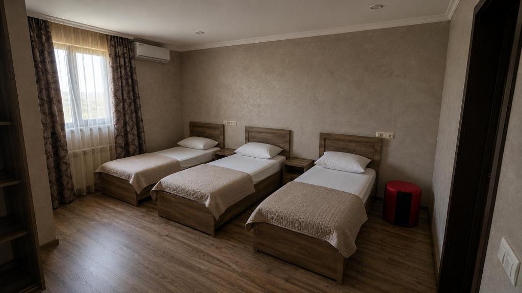 a room with three beds and a red suitcase at Guramishvili 7 in Kobuleti