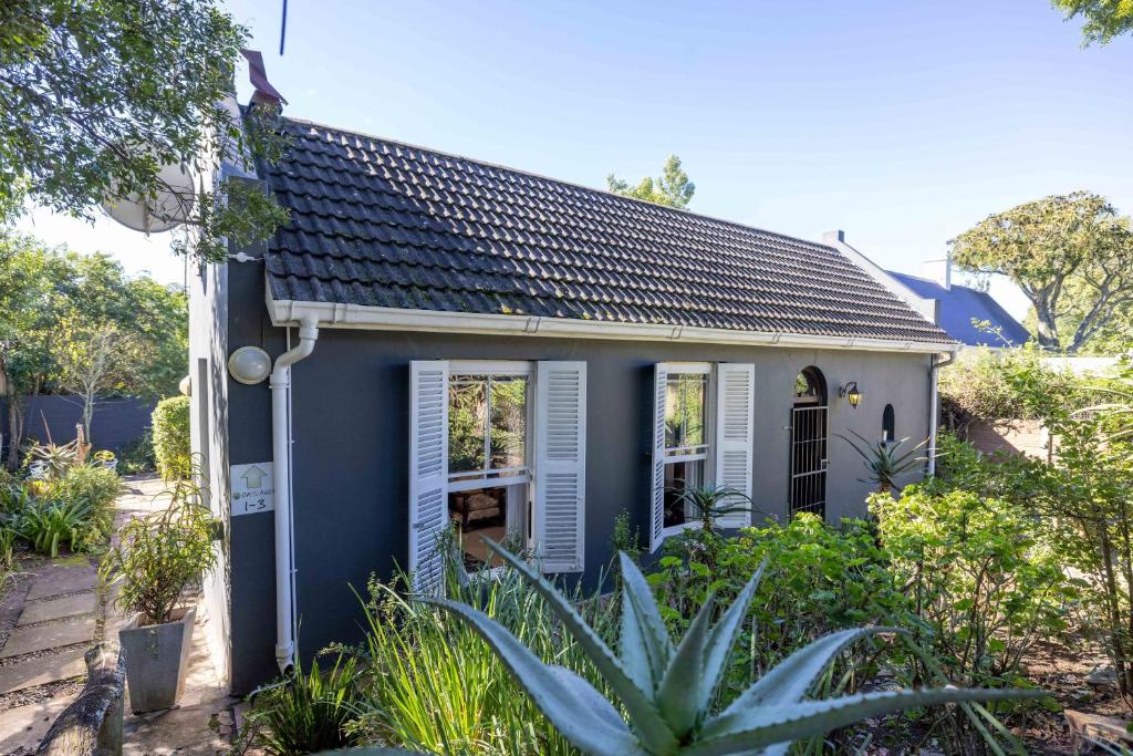 a blue house with white shutters and plants at 30 on Oatlands Accommodation Makhanda Grahamstown in Grahamstown