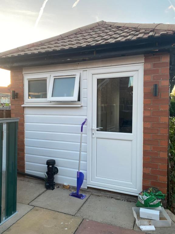 a garage with a mop next to a door at Keethz Home in Timperley