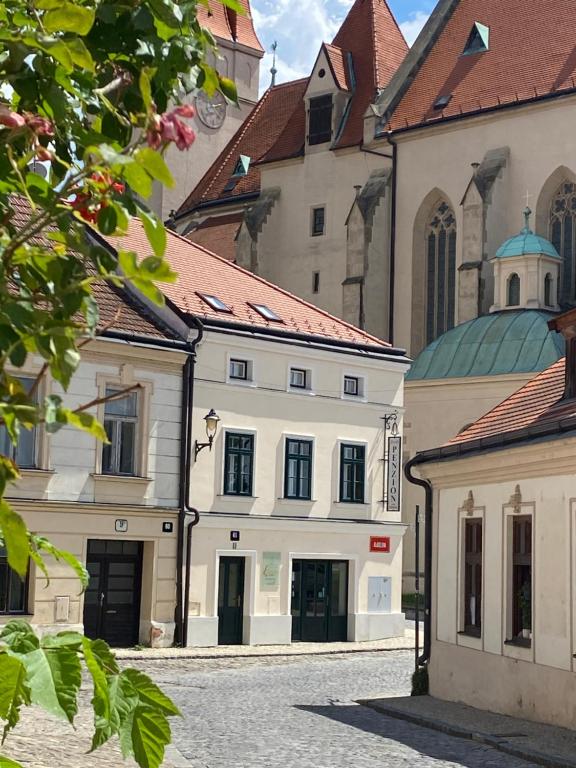 a large white building with a church in the background at Rezidence Zvon in Znojmo