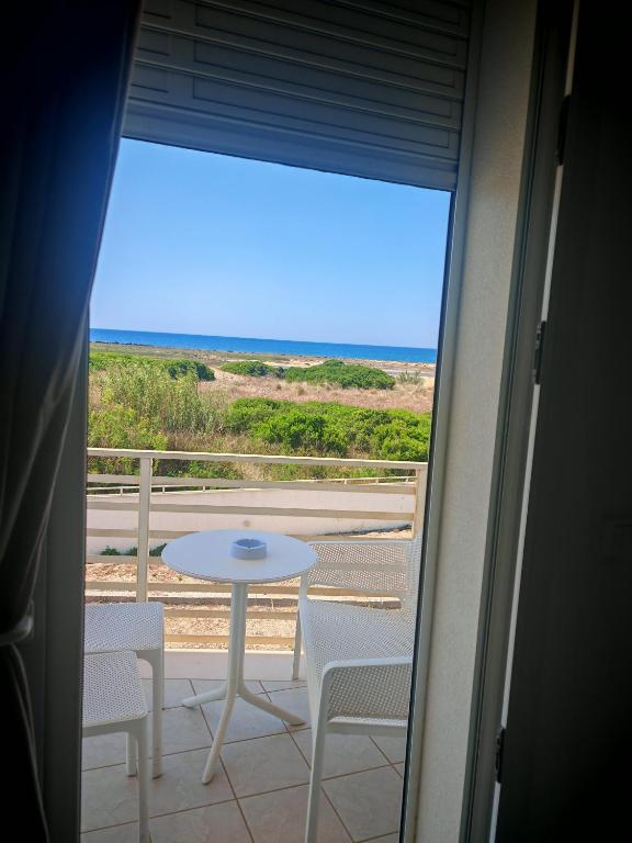 a balcony with a table and chairs and a view of the ocean at Sea Rooms - Torre Pali in Torre Pali