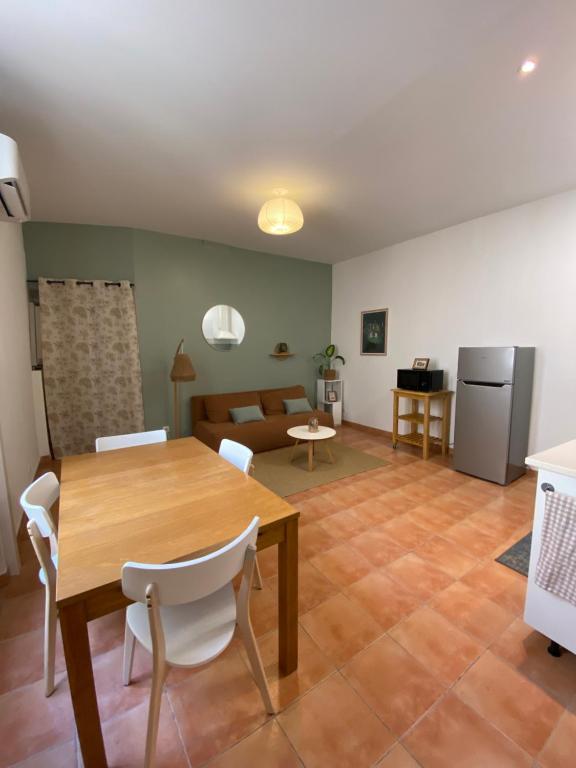 a dining room and living room with a table and chairs at APPARTEMENT Malana in Nîmes
