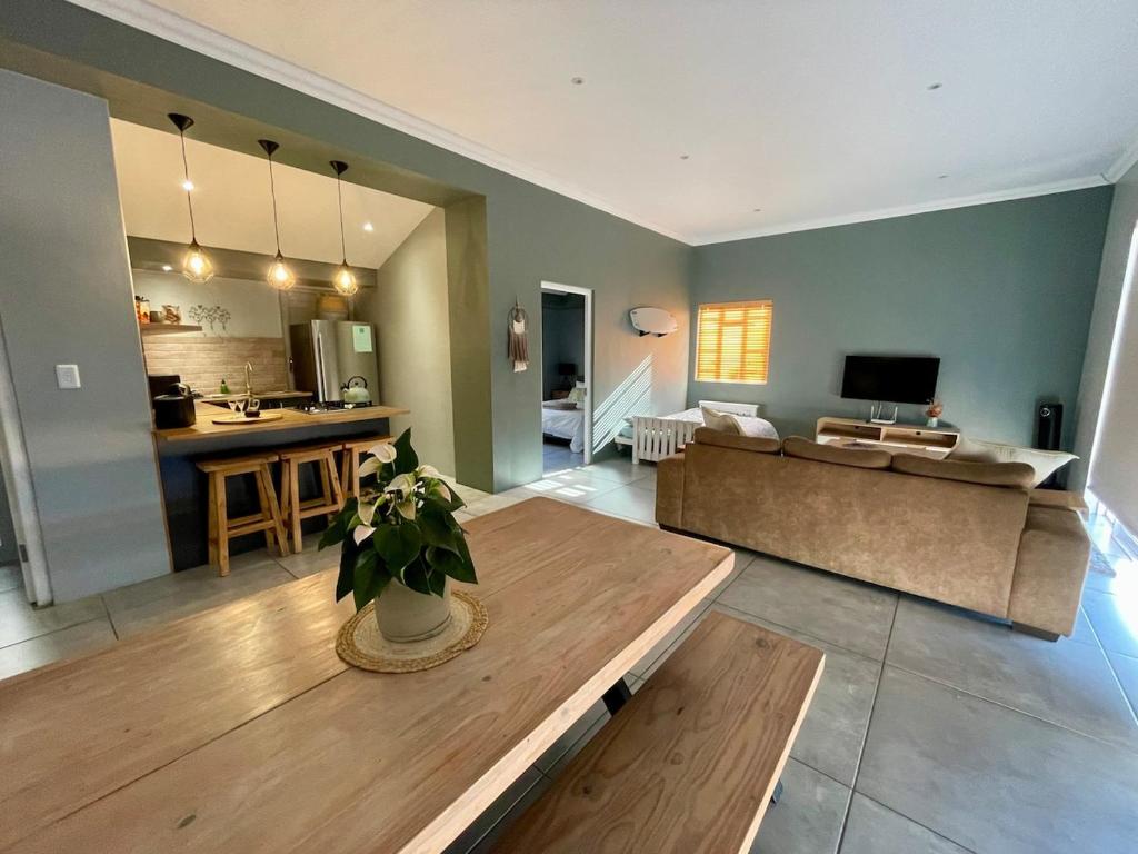 a living room with a couch and a table at The Kite Cottage in Langebaan
