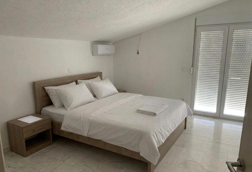 a bedroom with a bed with white sheets and white pillows at Elit Apartmani in Ulcinj
