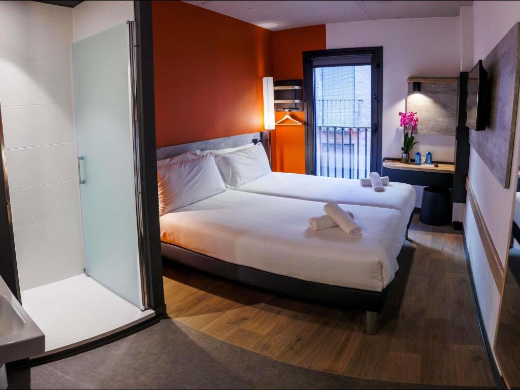 a bedroom with a large bed and a window at ibis budget Logroño Centro in Logroño