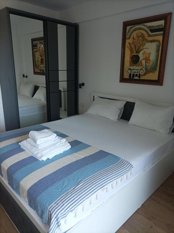 a bedroom with a large white bed with a mirror at Stefan - apartament studio in Saturn