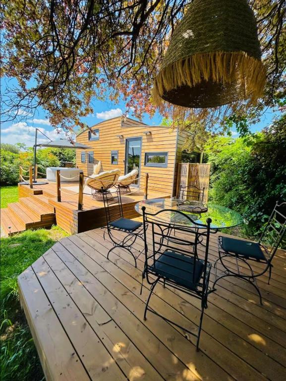 a deck with chairs and a table and a house at Tiny House avec jacuzzi privé - calme et nature in Grabels