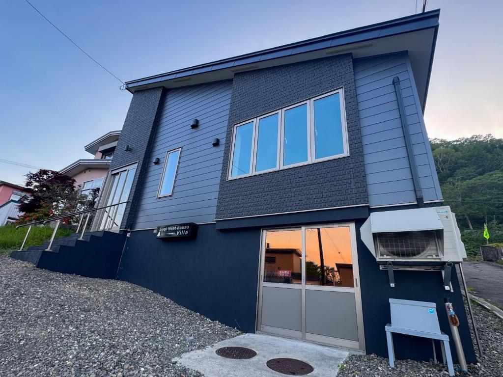 a blue house with a garage at Sugi Nest Rausu-villa- in Rausu