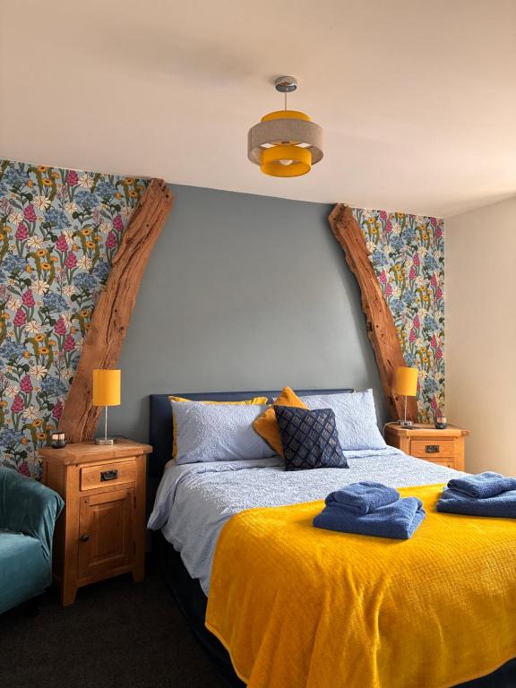 a bedroom with a bed with a yellow blanket at Cadwgan House in Rhayader