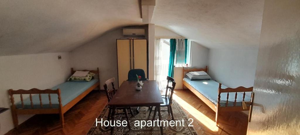 a room with two beds and a table and chairs at 10Forward apt2 in Bitola
