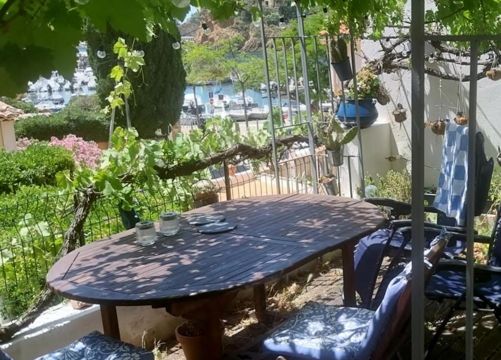 a picnic table in a garden with a view at Votre terrasse vue mer sous la vigne, un havre de paix in Ensuès-la-Redonne