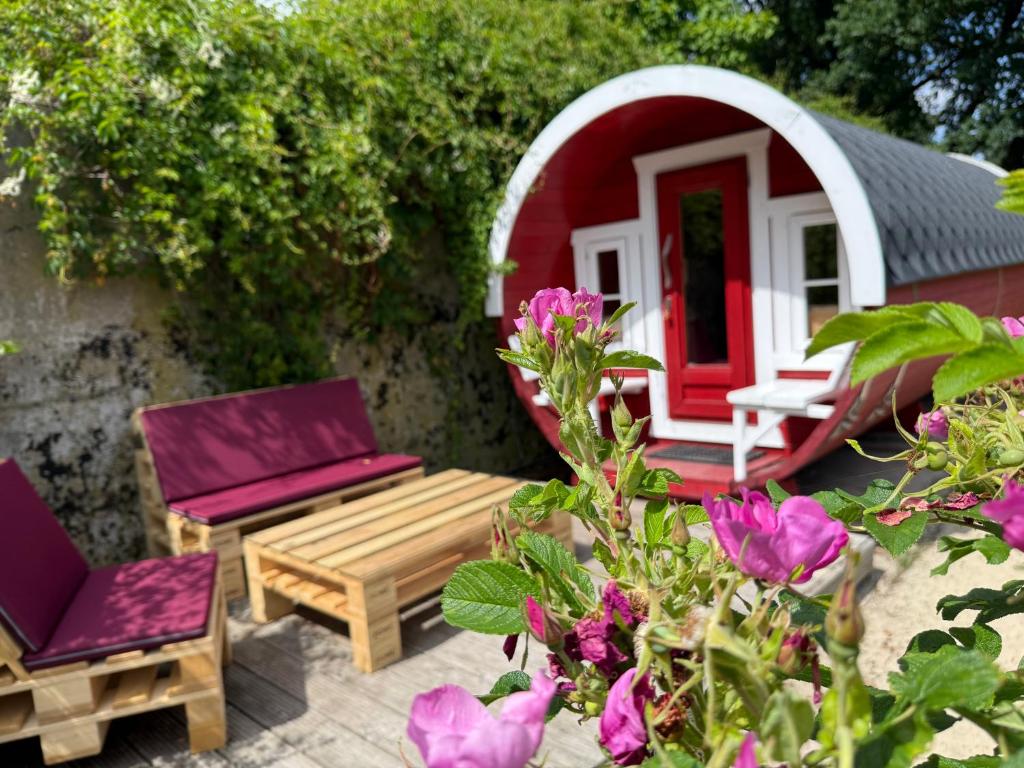 a garden with a bench and a red and white house at Wohnfass Fuchsbau in Walsrode